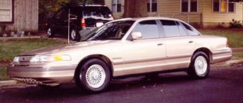 1993 Ford Crown Victoria - This 1993 Ford Crown Victoria is parked on a street with another vehicle in the background.