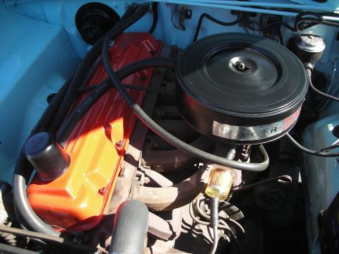 1998 Ford Crown Victoria - inline engine with an orange-painted valve cover and large black round air cleaner sits in a light blue engine bay.