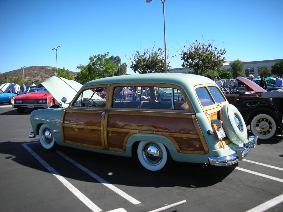 Rear three-quarter view of green woodie wagon with rear-mounted spare tire