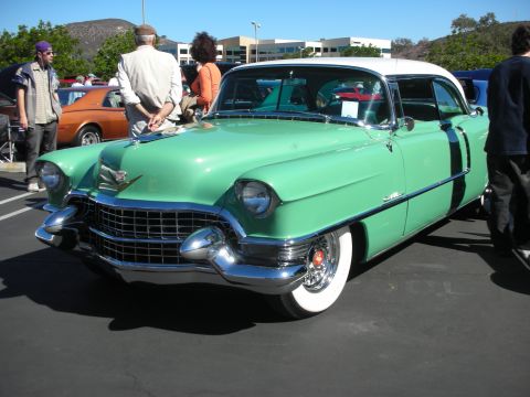 1998 Ford Crown Victoria - two-tone green-and-white 1950s Cadillac hardtop coupe parked at a car show with spectators in the background.