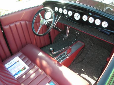 1998 Ford Crown Victoria - red leather hot-rod interior with a chrome banjo steering wheel, row of round gauges and a floor shifter.