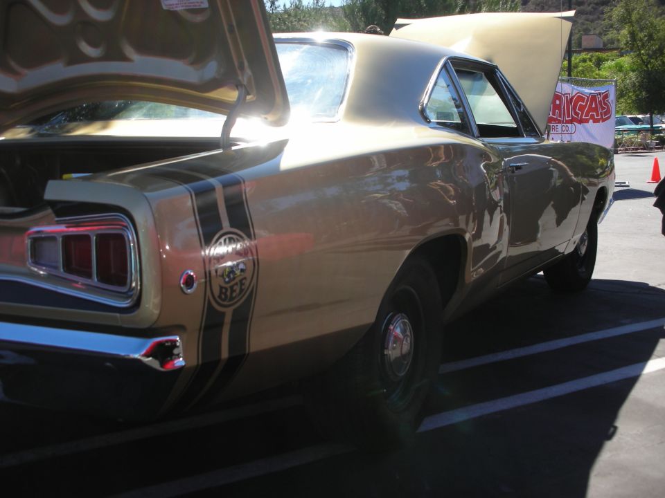 Rear quarter of gold Dodge Super Bee with bumblebee stripe and Bee emblem