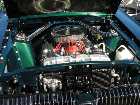 1998 Ford Crown Victoria - detailed Chevrolet small-block V8 with chrome air cleaner, red spark-plug wires and aluminum valve covers in a green car.