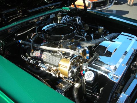 1998 Ford Crown Victoria - show-detailed V8 engine bay with chrome air cleaner and gold-anodized accessories in a green muscle car.
