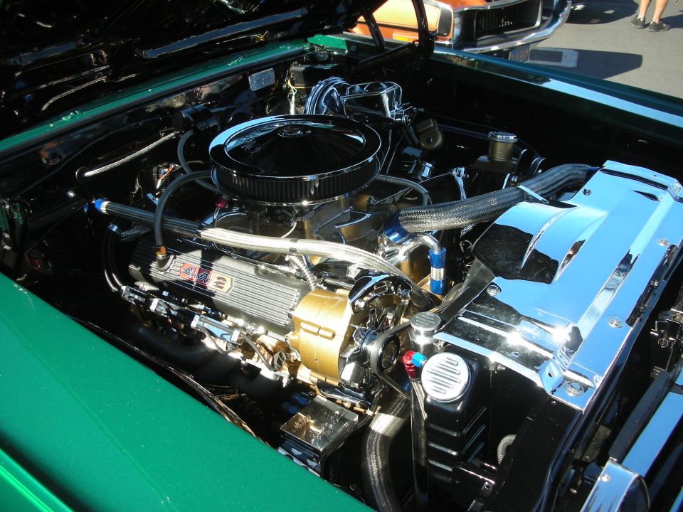 Chromed V8 engine with gold accents in a green muscle car