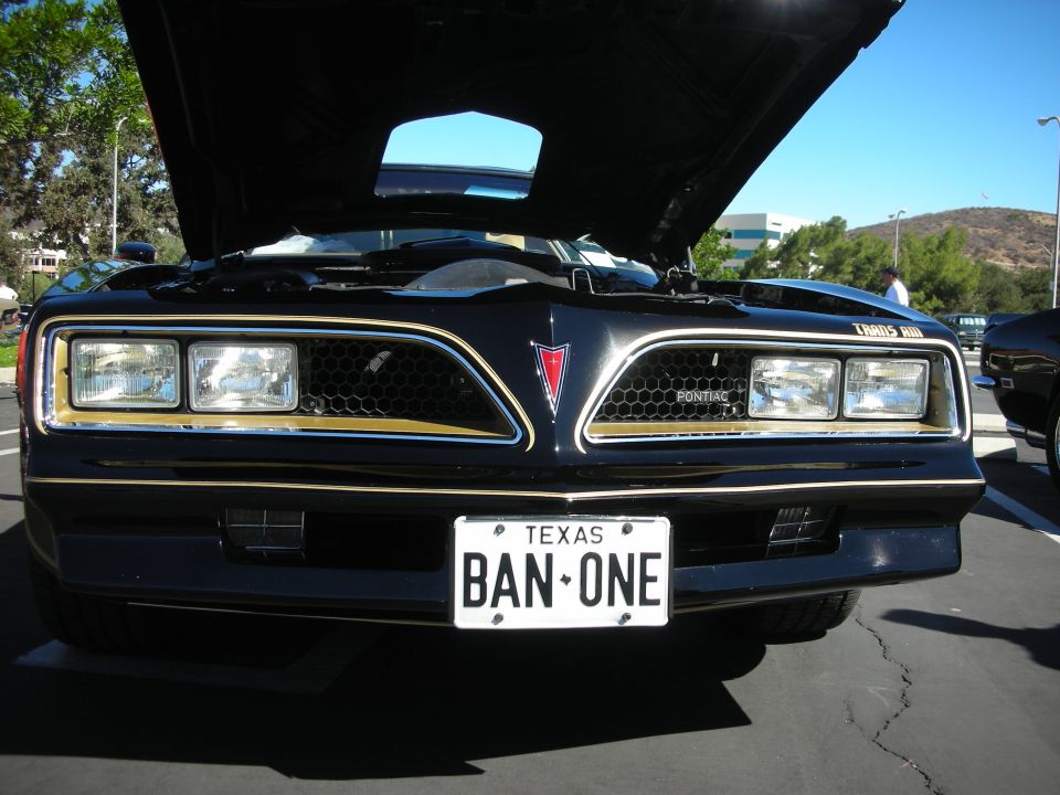 Front grille of black Pontiac Trans Am with Texas BAN-ONE plate
