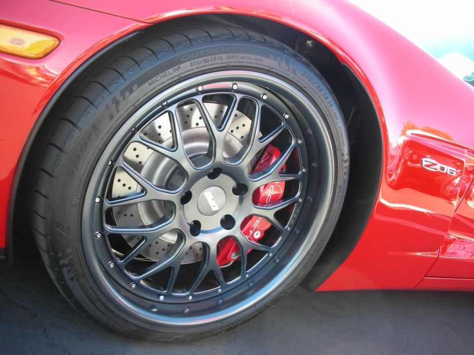 Close-up of a red car's gunmetal mesh wheel with red brake caliper