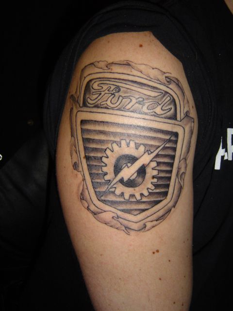1989 Ford Bronco - Tattoo of a Ford emblem on an arm, a gear and lightning bolt design.