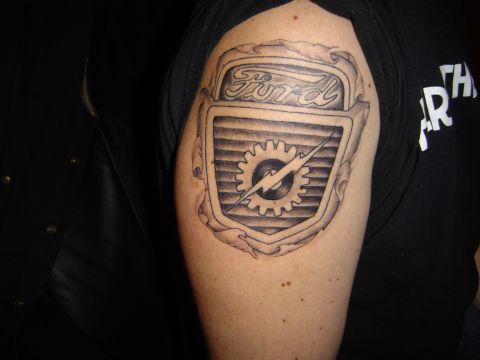1989 Ford Bronco - A tattoo of the Ford logo, a gear and lightning bolt, is displayed on a person's arm.