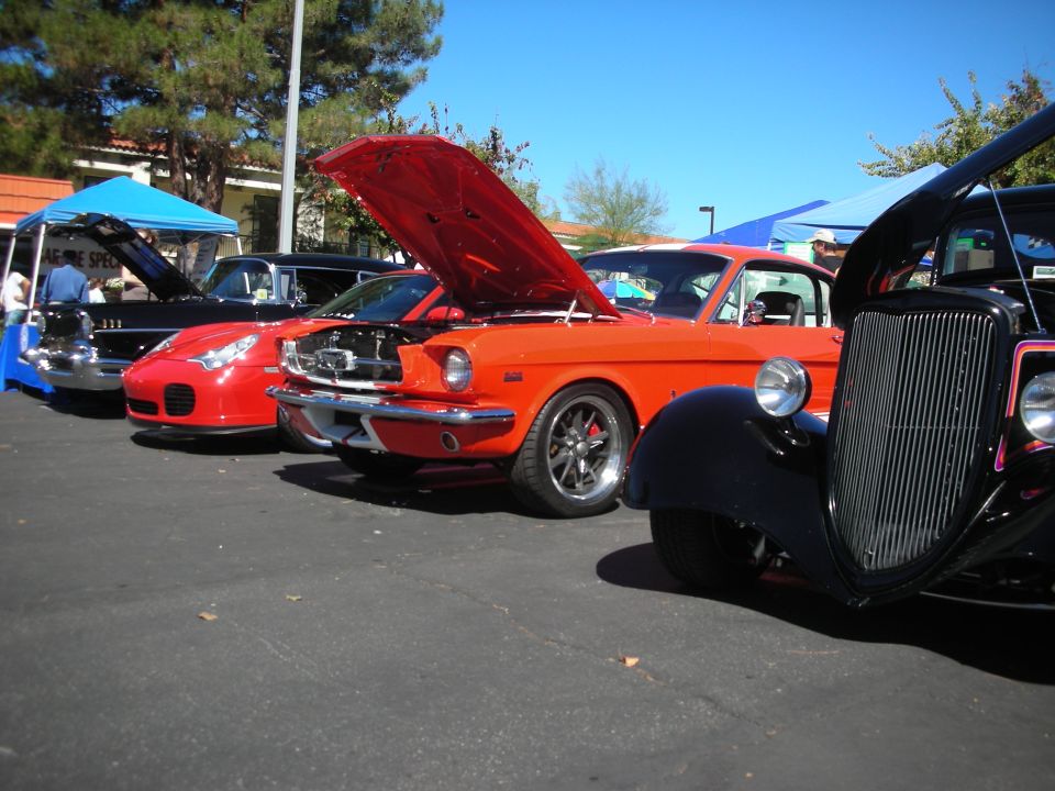 Orange Ford Mustang fastback in a row of show cars