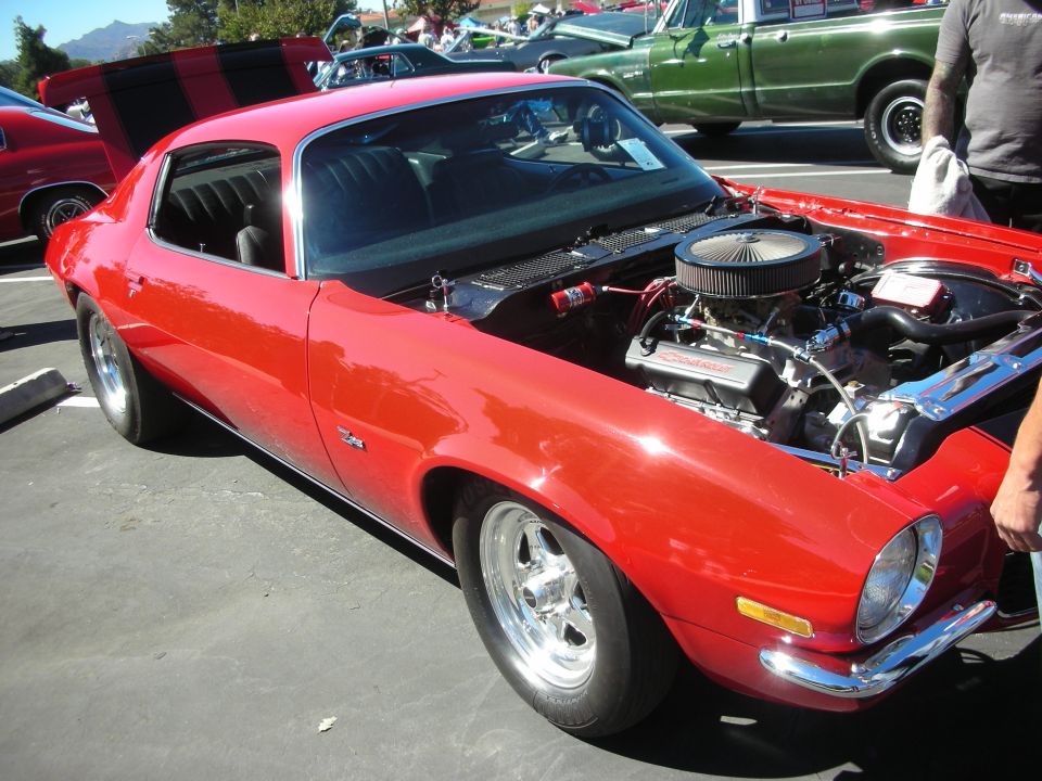 Red Camaro with open hood showing chrome V8 engine