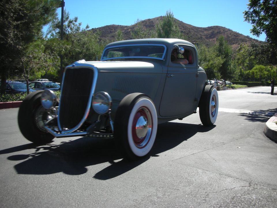 Gray primered 1930s hot rod coupe with whitewall tires