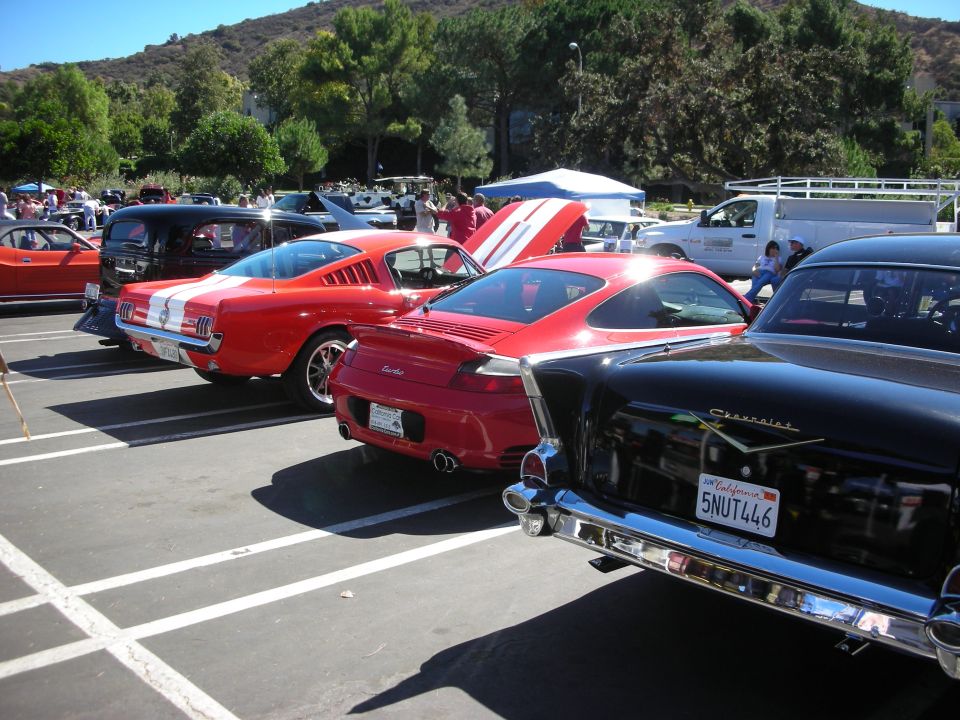 Rear view of red Mustang, Porsche 911 and black 1957 Chevrolet