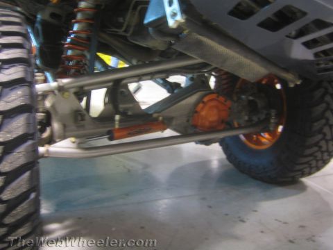 1990 Ford Bronco - Detailed undercarriage view of a custom off-road rig showing an orange differential, tubular links, coilover shocks and a skid plate.