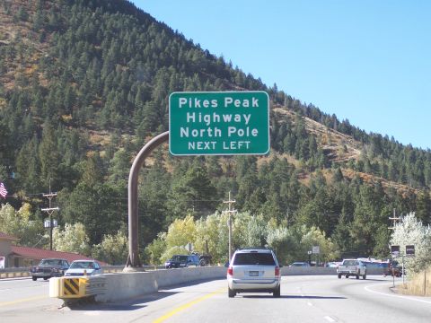 1972 Ford Ranchero - A highway sign directs traffic towards Pikes Peak Highway and the North Pole, with several vehicles visible on the road.