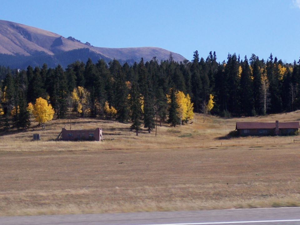 Rural landscape with autumn trees and old buildings