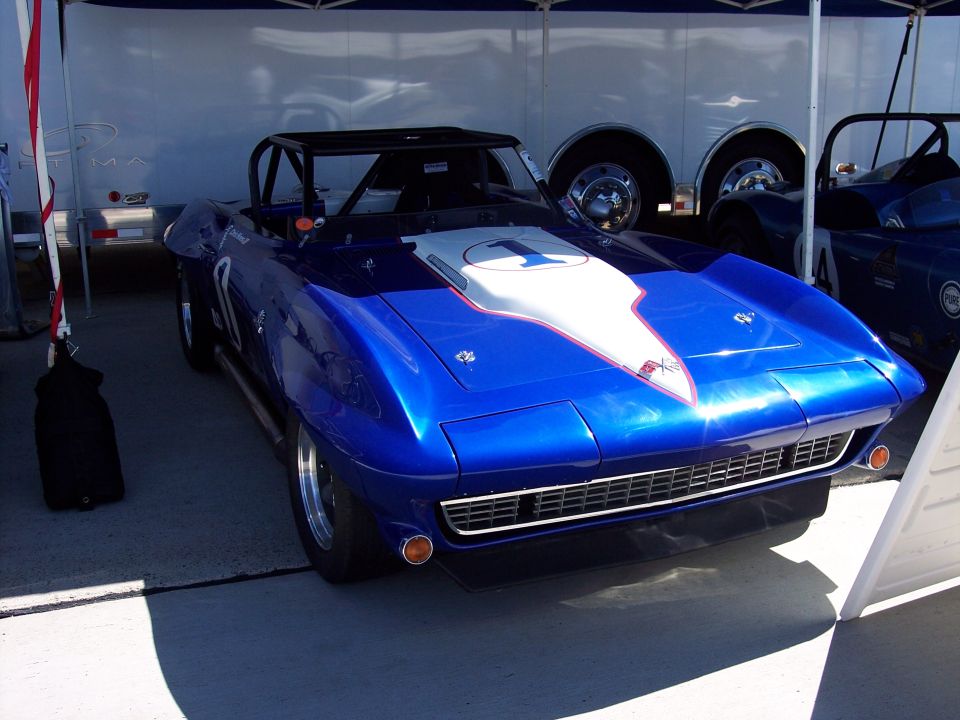Blue convertible race car with white stripe and number 1 on hood