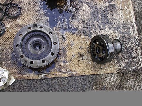1978 Ford Bronco - Close-up of differential components, likely removed for repair or inspection, resting on a stained mat.