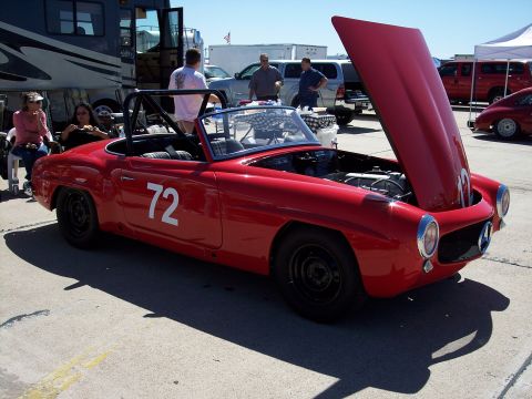 1971 Ford Mustang - Red convertible race car with number 72 on the door and hood open.