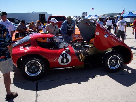 1971 Ford Mustang - A red racing car is displayed with its hood open, revealing the engine. Text on the hood identifies the sponsor.