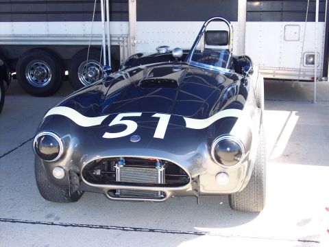 1971 Ford Mustang - A dark blue racing car with white racing stripes and the number 51 is parked in front of a trailer.