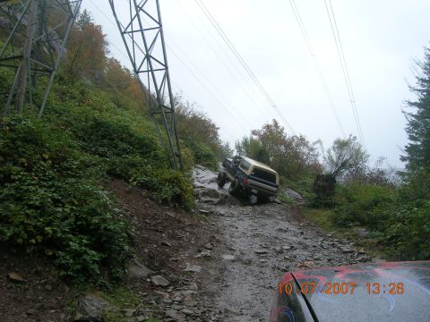 1996 Ford Bronco - 1996 Ford Bronco tackling a challenging off-road trail with steep inclines and rough terrain.