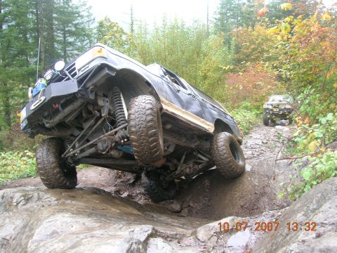 1996 Ford Bronco - This 1996 Ford Bronco is navigating a difficult off-road obstacle on a wooded trail.