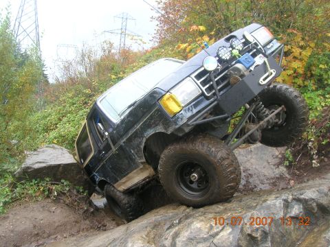 1996 Ford Bronco - This modified SUV is navigating a challenging rocky terrain.