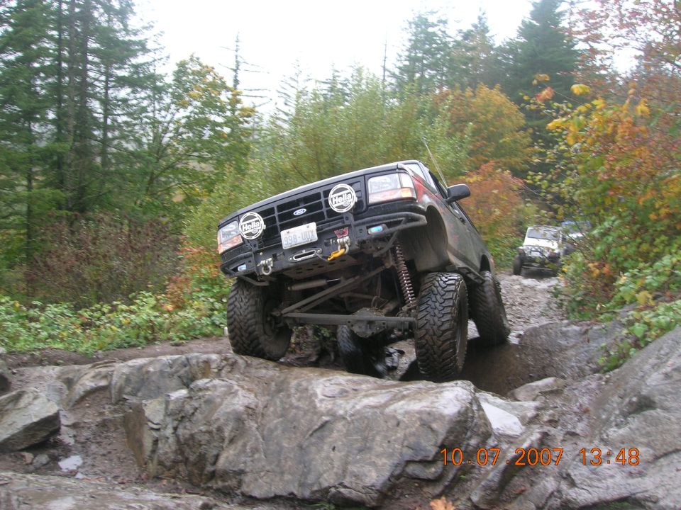 Black 1996 Ford Bronco navigating a rocky trail, with another vehicle behind