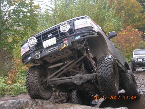 1996 Ford Bronco - 1996 Ford Bronco tackling a challenging off-road trail with a Jeep following.