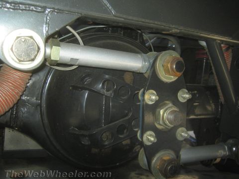 1990 Ford Bronco - close-up of a black brake or driveline component shows a machined mounting plate, hex fasteners and a hydraulic line.