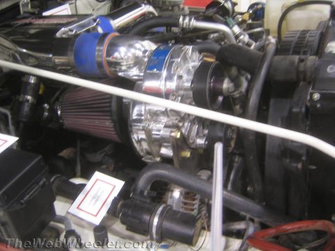 1990 Ford Bronco - close-up shows a polished centrifugal supercharger with a blue intake tube and cone air filter mounted in an engine bay.