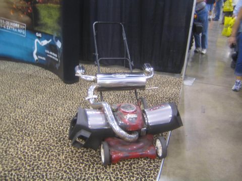 1990 Ford Bronco - red lawn mower fitted with twin chrome intakes and a polished muffler displayed on leopard carpet.