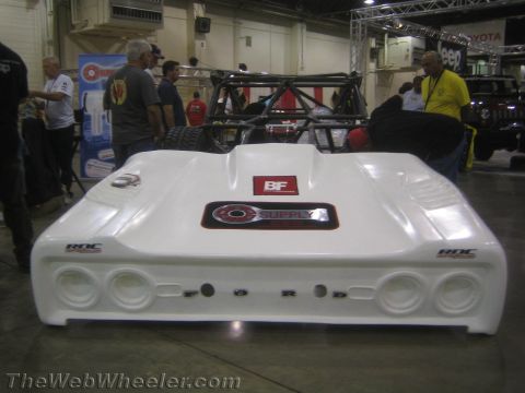 1990 Ford Bronco - rear of a white fiberglass-bodied tube-chassis off-road race car with round taillight cutouts at a show.