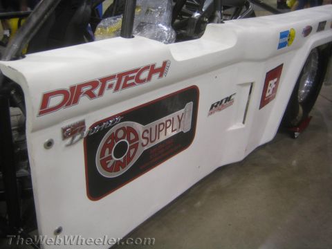1990 Ford Bronco - white side body panel of a race car bearing Dirt-Tech and Rod End Supply graphics and other sponsor stickers.