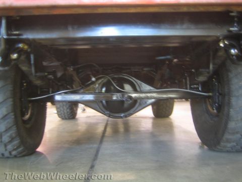 1990 Ford Bronco - underside of an off-road truck shows the rear differential, leaf springs and shock setup between the wheels.