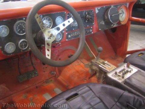 1990 Ford Bronco - driver's area of a stripped off-road truck features a polished drilled three-spoke steering wheel, a bank of round gauges and a floor shift…