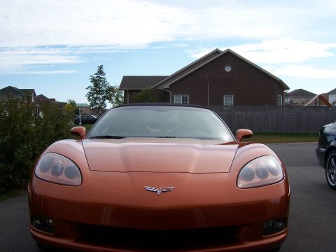 1996 Ford Bronco - Front view of an orange sports car parked in a suburban driveway.