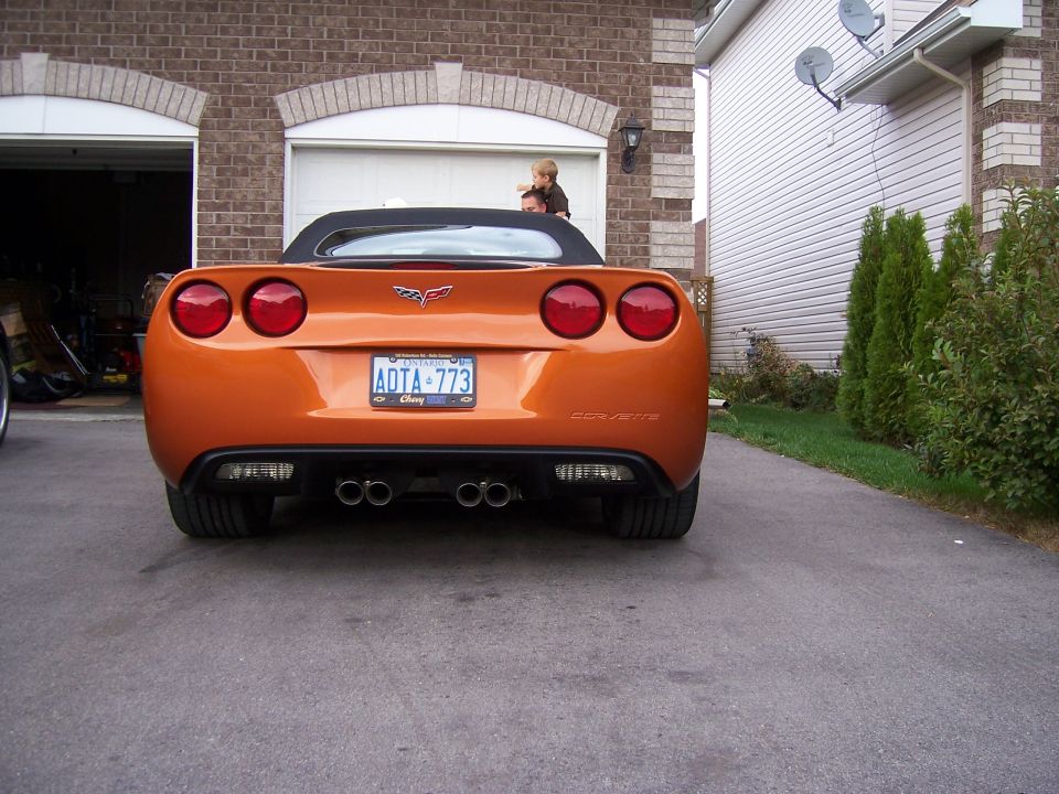 Rear of orange C6 Corvette convertible with quad taillights and Ontario plate