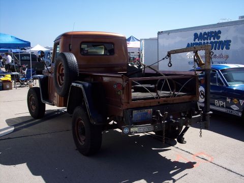1971 Ford Mustang - A vintage pickup truck is parked next to a blue car, with a tow crane mounted in its bed.