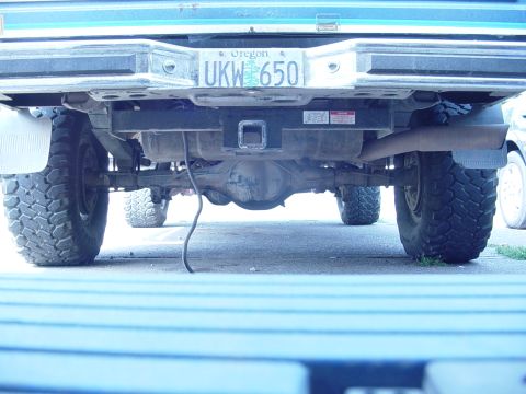 1985 Ford Bronco - The rear view of a truck shows its bumper, license plate, and undercarriage components.