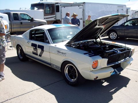 1971 Ford Mustang - White 1965 Ford Mustang GT350 race car with hood open, parked outdoors.