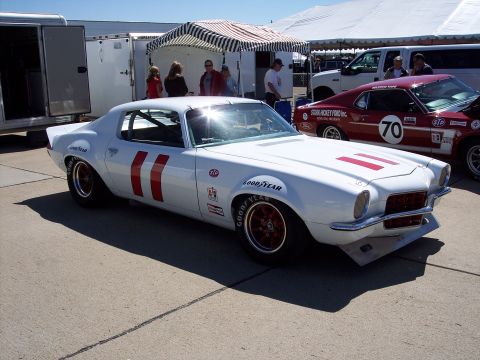 1971 Ford Mustang - A white 1970 Chevrolet Camaro race car with red racing stripes and Goodyear tires is parked outdoors.