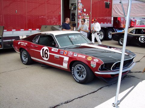 1971 Ford Mustang - Race-prepped 1970 Ford Mustang Boss 302, number 16, sits ready for action next to a support trailer.