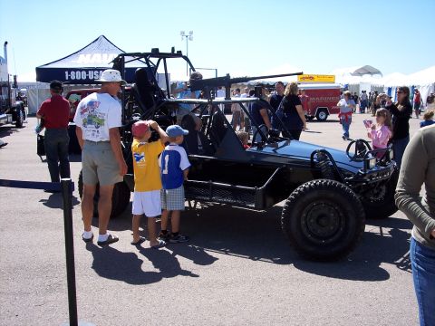 1971 Ford Mustang - A military-style buggy with a mounted machine gun is on display, attracting attention from onlookers.