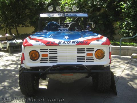 1990 Ford Bronco - Head-on view of a stars-and-stripes BC Broncos race truck with round amber lights, a roof light bar reading Old Horse Racing.