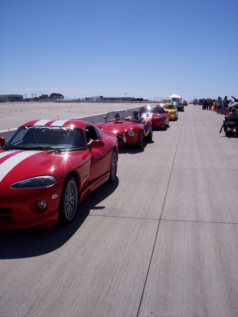1971 Ford Mustang - Multiple sports cars, including a red Dodge Viper, are parked in a line on a paved surface.