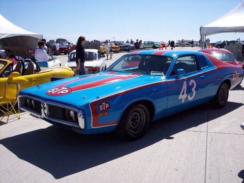1971 Ford Mustang - A blue and red race car with STP decals and the number 43 is parked at an outdoor event.
