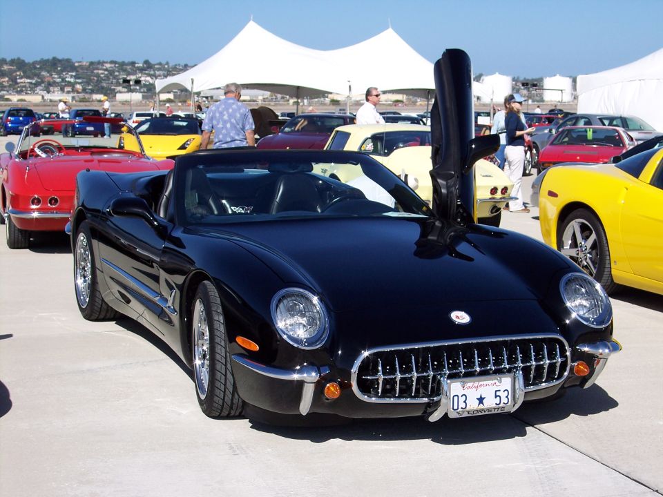 Black convertible sports car with butterfly doors, chrome grille, and California license plate
