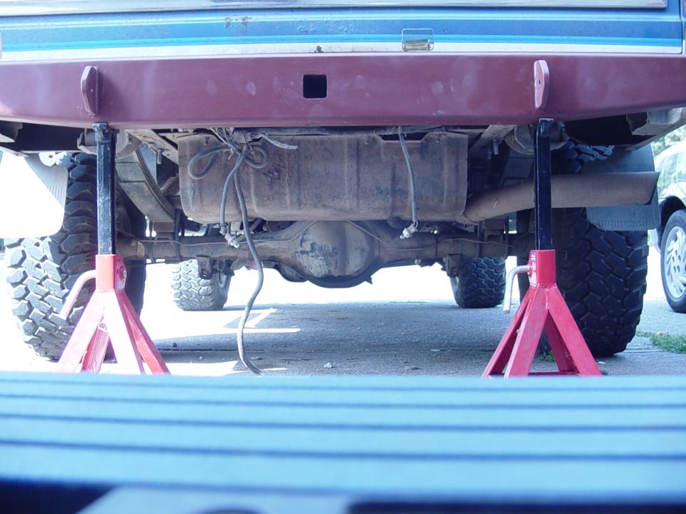 1985 Ford Bronco rear axle and fuel tank on jack stands, showing suspension and exhaust